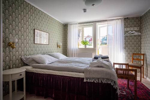 a bedroom with a large bed with a window at Fregatten Bed & Breakfast in Karlskrona