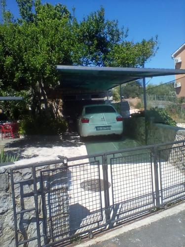 a car parked in a parking lot behind a fence at apartman-maja-krk in Krk