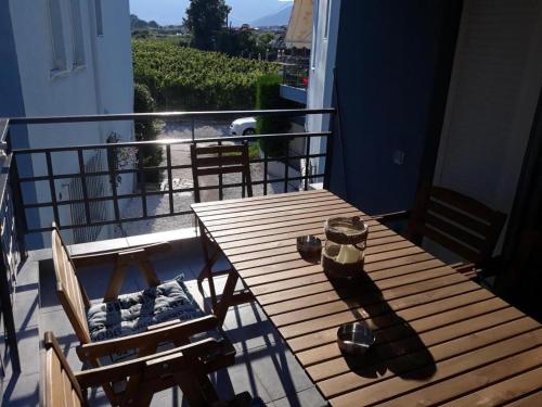 ein Holztisch und Stühle auf einem Balkon mit Aussicht in der Unterkunft Τhe Diamond in Néa Péramos