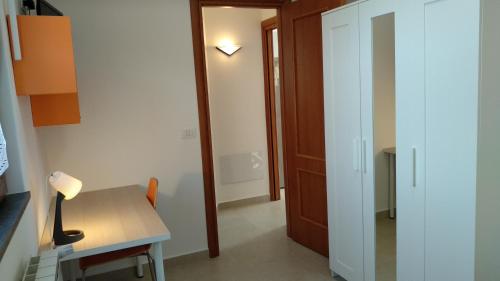 a room with a desk and a table with a lamp at Seven in Trecastagni