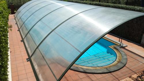 an overhead view of a curved pool with a glass roof at Seven in Trecastagni