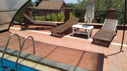 two chairs and a table next to a swimming pool at Seven in Trecastagni