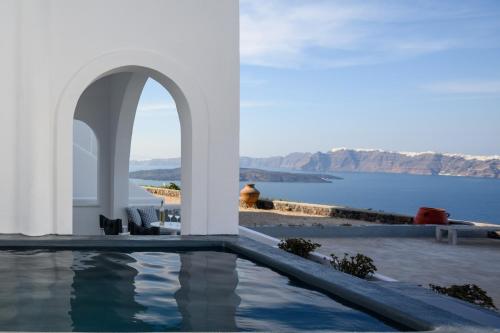 ein Haus mit einem Pool mit Blick auf das Wasser in der Unterkunft Kalestesia Suites in Akrotiri