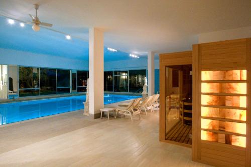 a living room with a pool with a ceiling fan at Bellavista Terme Resort & Spa in Montegrotto Terme