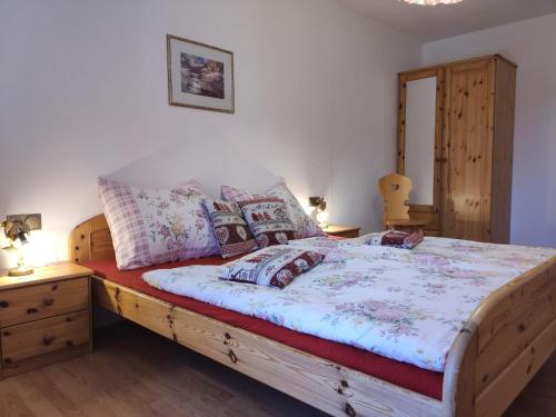 una camera da letto con un grande letto in legno con cuscini di Obkirchhof a Senale-San Felice
