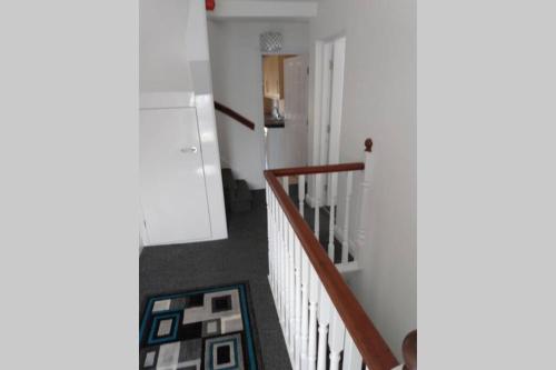 un pasillo con una escalera con paredes blancas y una escalera en place by the sea, en Bridlington