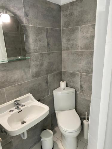 a bathroom with a white toilet and a sink at Studios Argyris in Poros