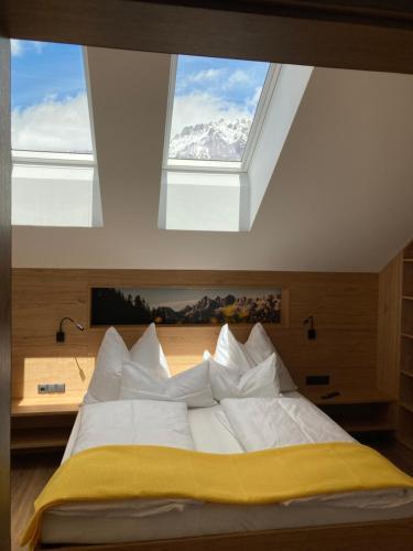 a bedroom with a bed with a large window at Deluxe Appartement Blasbichlerhof in Ramsau am Dachstein