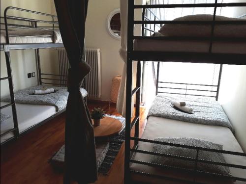 a room with three bunk beds and a table at Urban Yoga House Hostel & Retreat in Ioannina