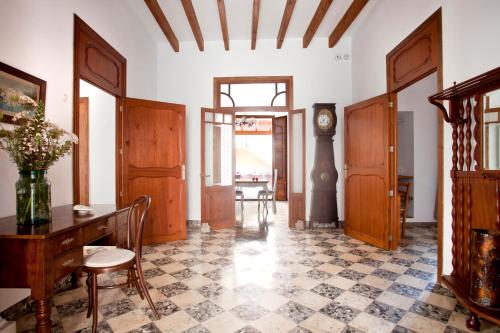 a room with a table and chairs and a clock at Casal de Petra - Rooms & Pool by My Rooms Hotels TI in Petra