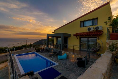 a villa with a swimming pool in front of a house at Santakira Villas in Parga