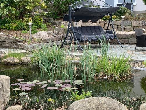 a bed in a garden with a pond with lilies at Hotel-Pension Teutonia in Braunlage