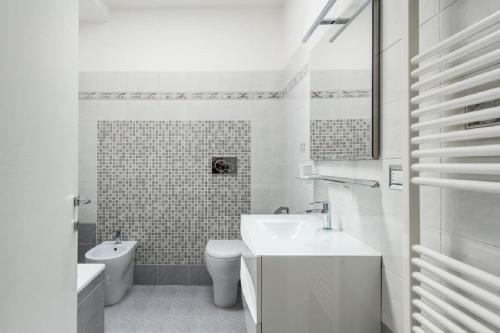 ルッカにあるSun Terrace Appartmentの白いバスルーム(洗面台、トイレ付)