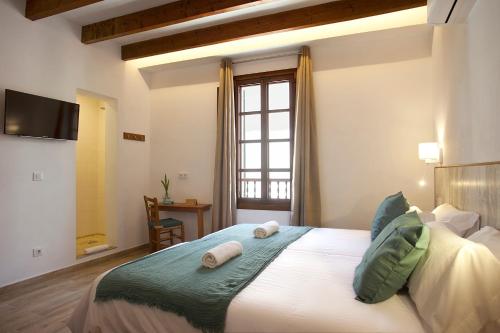 a bedroom with a bed with two towels on it at Casal de Petra - Rooms & Pool by My Rooms Hotels TI in Petra