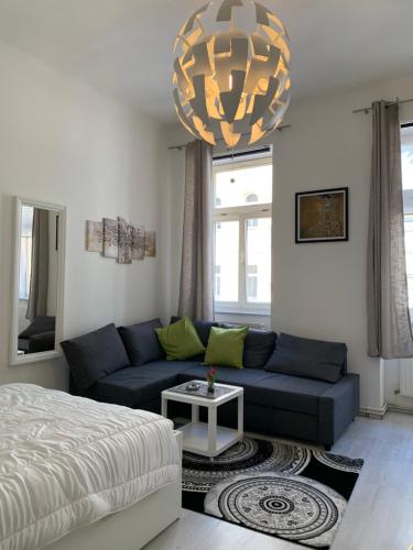 a living room with a blue couch and a chandelier at centrally & comfortable in Vienna