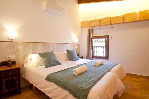 a bedroom with a large bed with two towels on it at Casal de Petra - Rooms & Pool by My Rooms Hotels TI in Petra