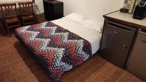 łóżko z kolorowym kocem w pokoju w obiekcie Zaccheo 9 w mieście Pitigliano