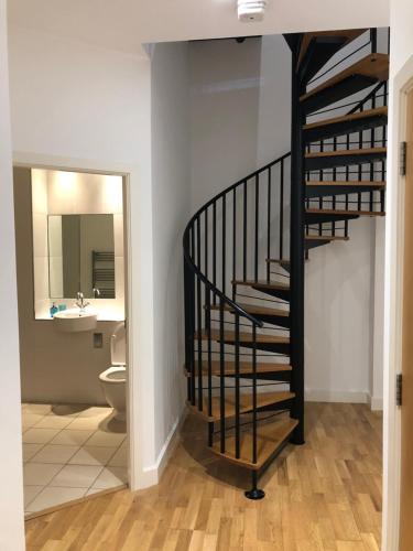 a black spiral staircase in a bathroom with a sink at Heart of YORK in York