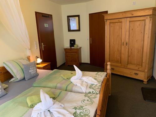 two beds in a bedroom with towels on them at Hotel-Pension Teutonia in Braunlage