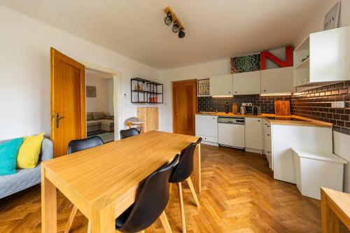 cocina y comedor con mesa de madera y sillas en Vila Republika en Malá Skála