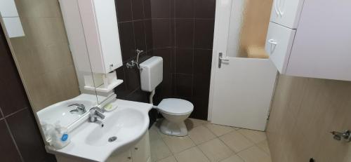 een badkamer met een witte wastafel en een toilet bij Stan na dan Predah in Užice