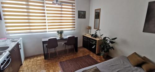 een kleine woonkamer met een tafel en een keuken bij Stan na dan Predah in Užice