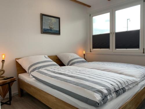 2 Betten in einem Schlafzimmer mit 2 Fenstern in der Unterkunft Weser Nah in Fünfhausen