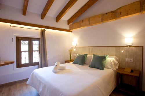 a bedroom with a large white bed with green pillows at Casal de Petra - Rooms & Pool by My Rooms Hotels TI in Petra