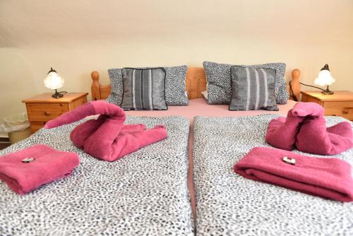 a bedroom with pink towels on a bed at Hotel-Pension Teutonia in Braunlage