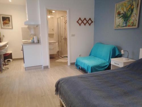 um quarto com uma cama e uma cadeira azul em Apartments Haracic em Hvar