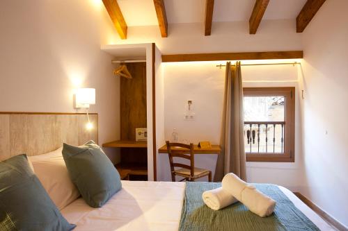 a bedroom with a bed and a desk and a window at Casal de Petra - Rooms & Pool by My Rooms Hotels TI in Petra