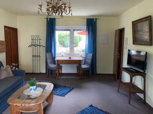 a living room with a table and a blue couch at Hotel-Pension Teutonia in Braunlage