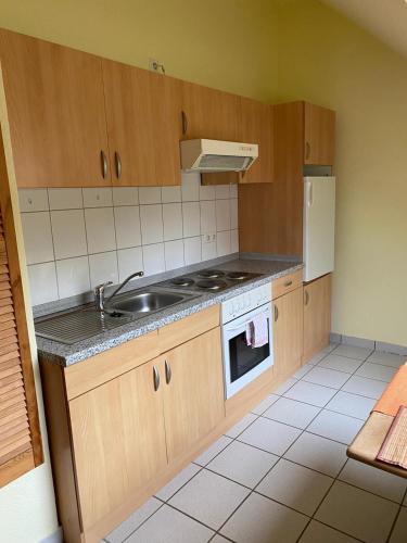 a kitchen with a sink and a stove at Hotel-Pension Teutonia in Braunlage