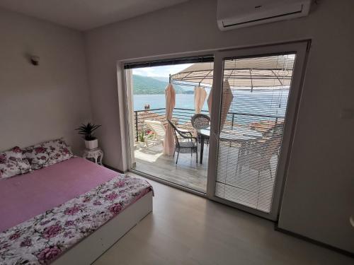 a bedroom with a bed and a balcony with a view at Apartment Ain Naum in Ohrid