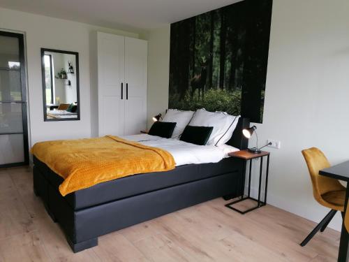 een slaapkamer met een groot bed en een bureau bij B&B Speulderveld in Ermelo