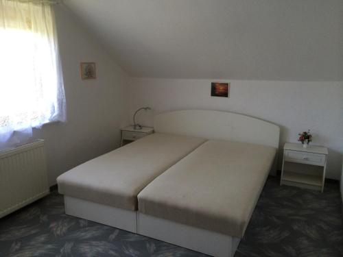 een slaapkamer met een groot bed en twee nachtkastjes bij Frankie Holiday Apartment I. in Balatongyörök