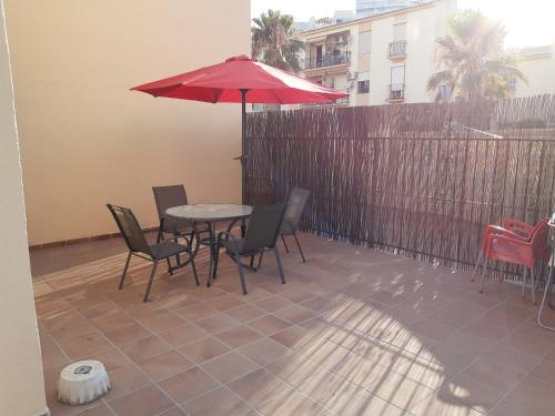 taras ze stołem, krzesłami i parasolem w obiekcie Oasis Playamar w mieście Torremolinos