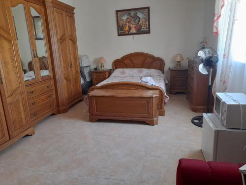 a bedroom with a wooden bed and wooden cabinets at Private room in Qormi
