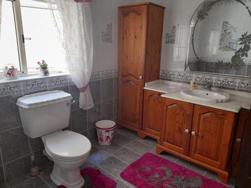 a bathroom with a toilet and a sink and a mirror at Private room in Qormi