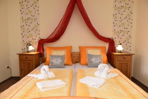 a bedroom with a bed with towels on it at Hotel-Pension Teutonia in Braunlage