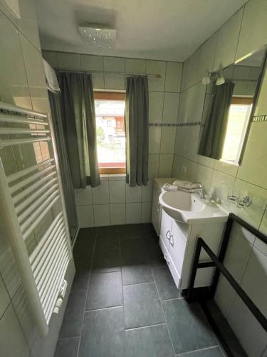 a white bathroom with a sink and a mirror at Appartements Alpenblick in Finkenberg