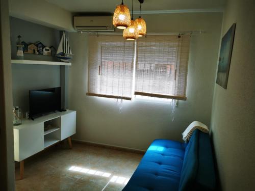 a living room with a blue couch and a television at Rihuete 2 in Puerto de Mazarrón
