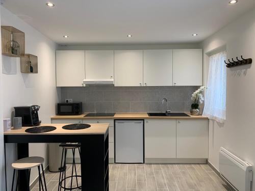 a kitchen with white cabinets and a counter top at Maisonnette en hyper centre d’Orléans in Orléans