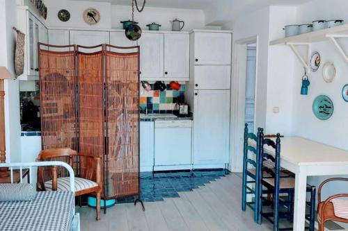 a kitchen with white cabinets and a table and a table at CASA DA ZECA, GARAGEM GRATUITA, COSTA NOVA in Gafanha da Encarnação