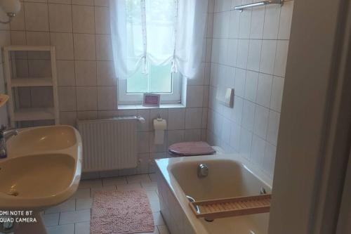 y baño con bañera, aseo y lavamanos. en Große Ferienwohnung von Beethoven mit Kamin Terrasse, en Schloss Holte-Stukenbrock