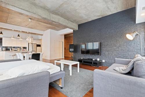 a bedroom with a bed and a couch and a tv at mtlFlats - Condotel Le Luxe in Montréal