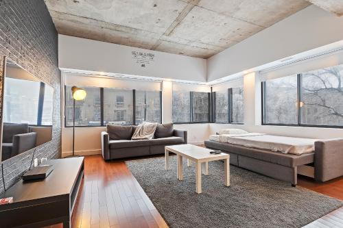 un salon avec un lit et un canapé dans l'établissement mtlFlats - Condotel Le Luxe, à Montréal
