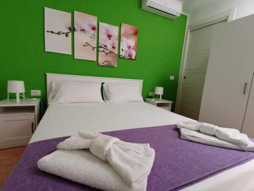 - une chambre avec un lit blanc et des serviettes dans l'établissement Sognando Lampedusa, à Lampedusa