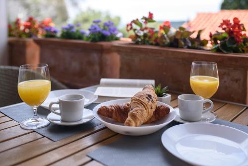 a table with a plate of bread and two glasses of orange juice at Villa Leoni in Dubrovnik