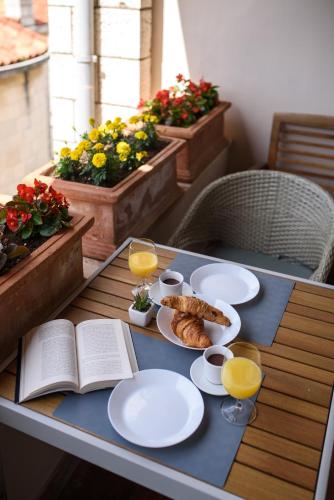 a table with plates of food and an open book at Villa Leoni in Dubrovnik